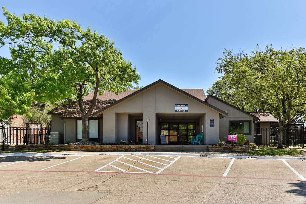 A small building with a parking lot in front.