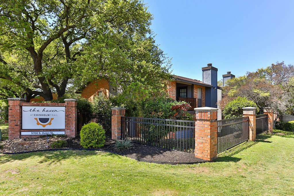 A sign that says "The Harvest" is in front of a house.