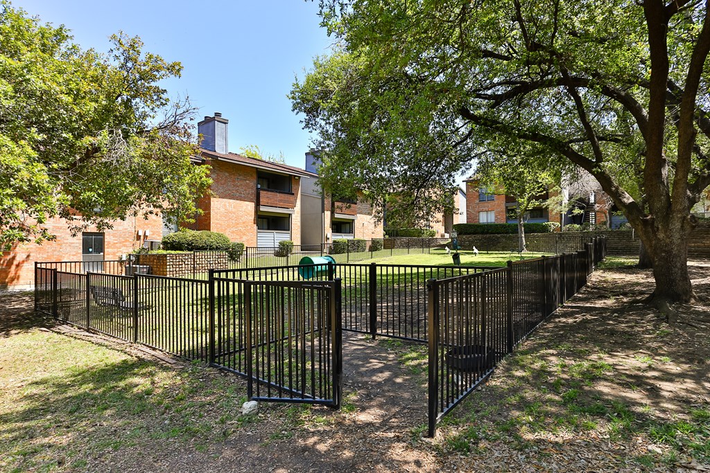 A black metal fence surrounds a green lawn.