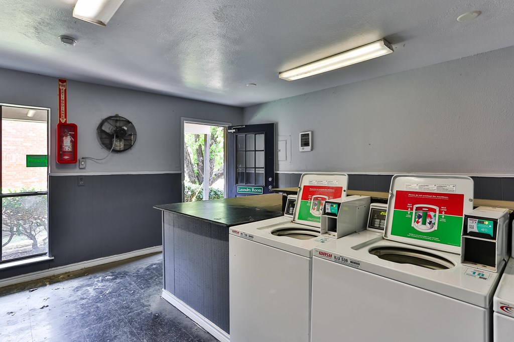 A room with a grey wall and a fan on the wall.