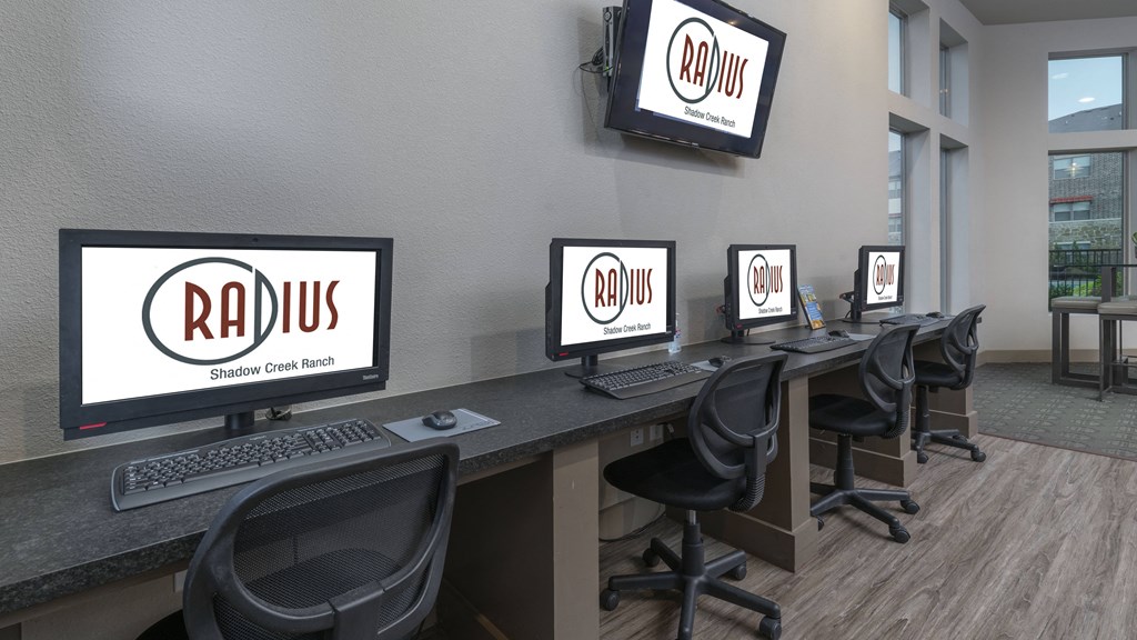 a group of computers on a desk in a room