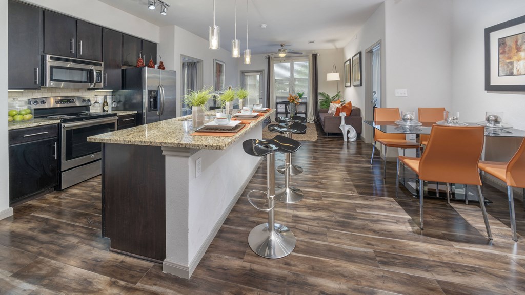 a kitchen and dining room area with a long counter and a table with chairs
