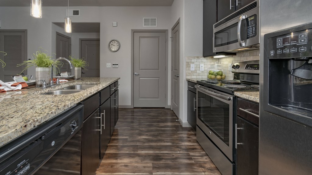 a kitchen with stainless steel appliances and granite counter tops
