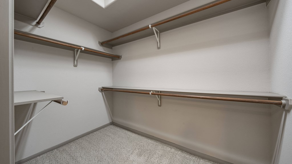 a walk in closet with a bench and a table