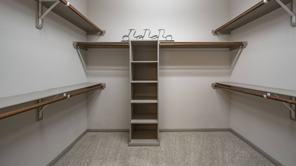 a walk in closet with empty shelves and a ladder