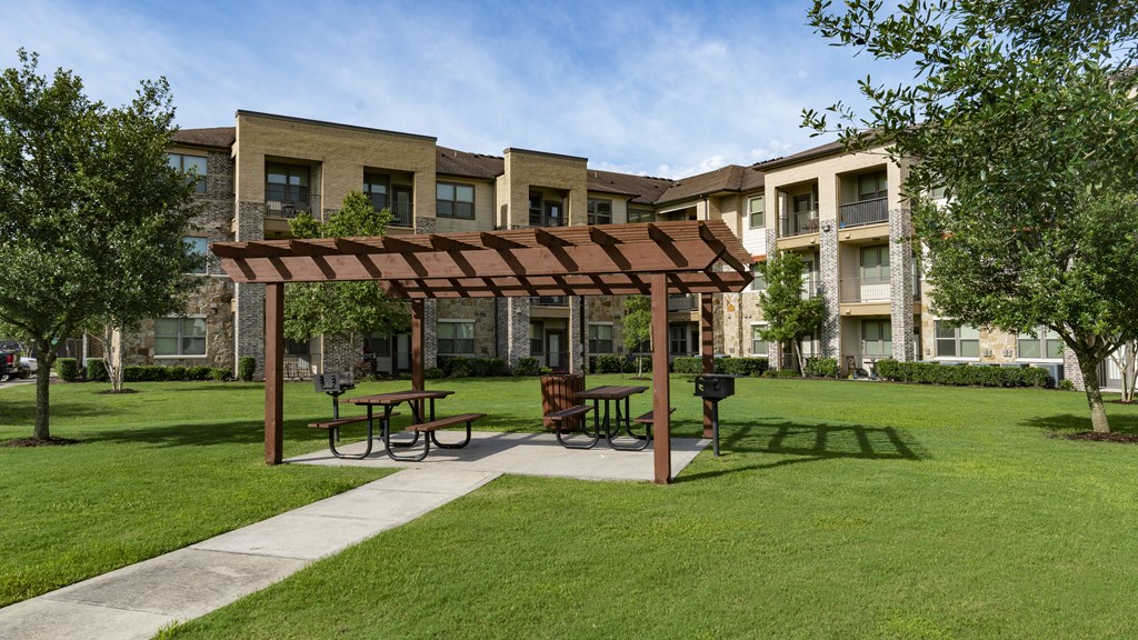 a park with a picnic area in front of an apartment building