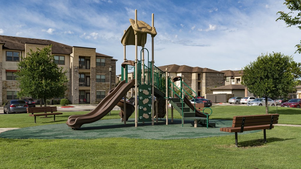 a playground in a park in front of an apartment building