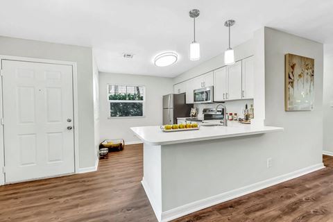 a kitchen with a white counter top and a white door