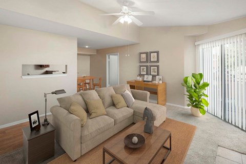 Living room with plush sofa, ceiling fan, and sliding glass doors.