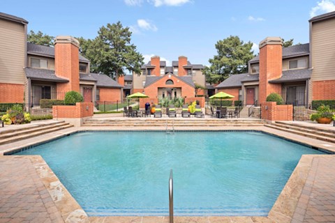 Outdoor pool with surrounding patio seating and landscaped courtyard views.