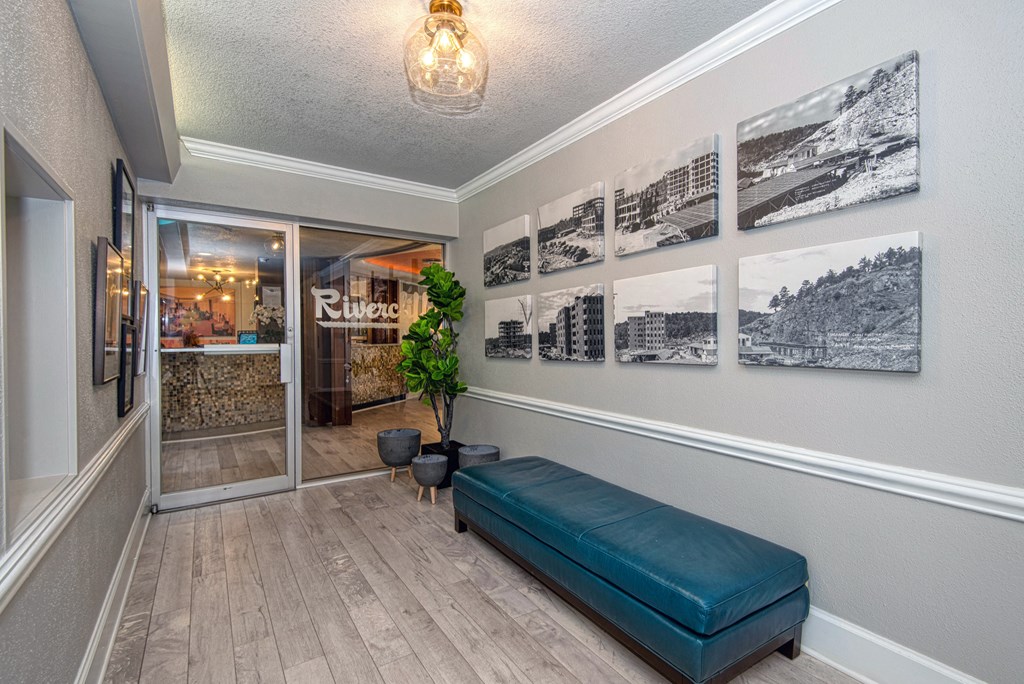 a hallway with a bench and pictures on the wall