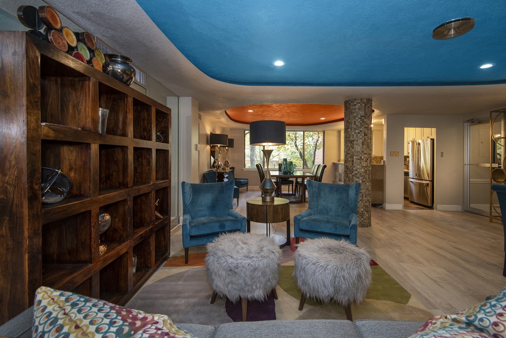 a living room filled with furniture and a blue ceiling