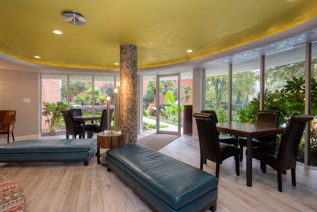 a living room with a large yellow ceiling and large windows