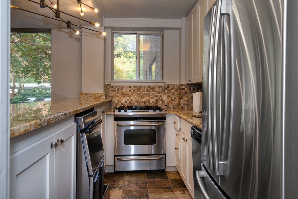 a kitchen with white cabinets and stainless steel appliances