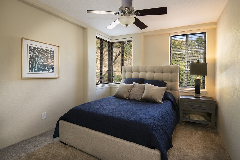 a bedroom with a bed and a ceiling fan
