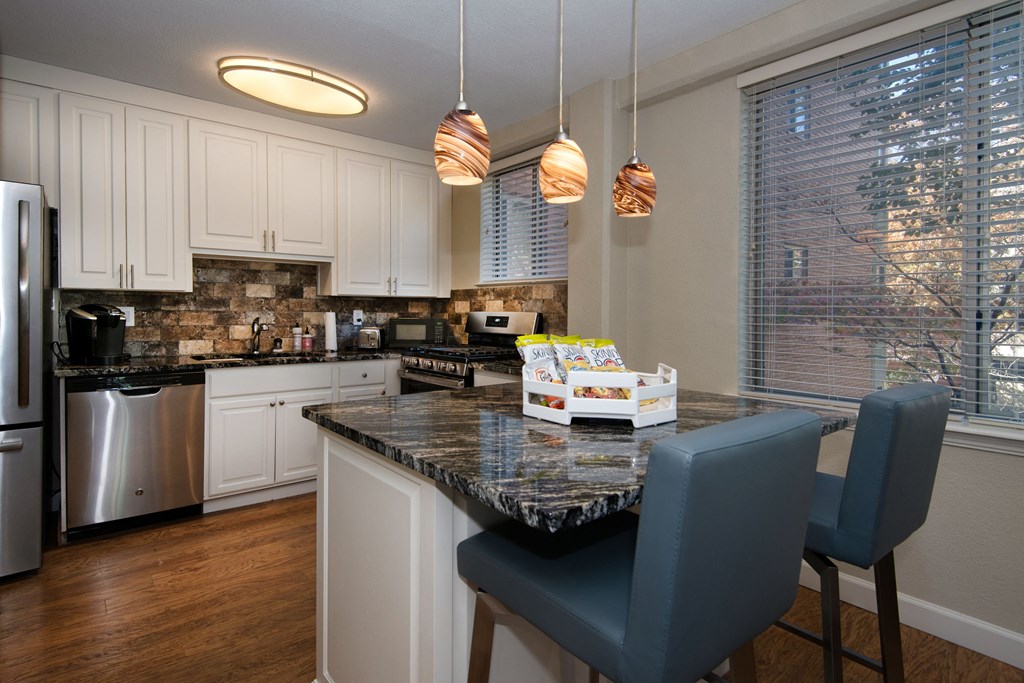 a kitchen with white cabinets and a granite counter top