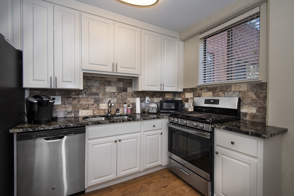 a kitchen with white cabinets and stainless steel appliances