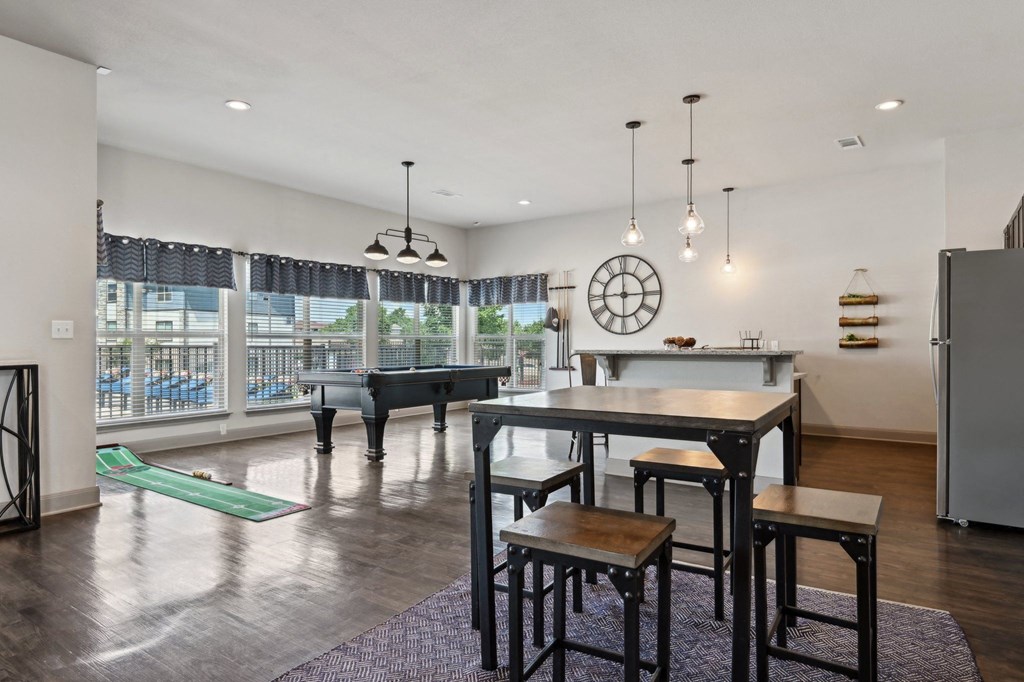the gathering room has a large table with chairs and a piano and a large window