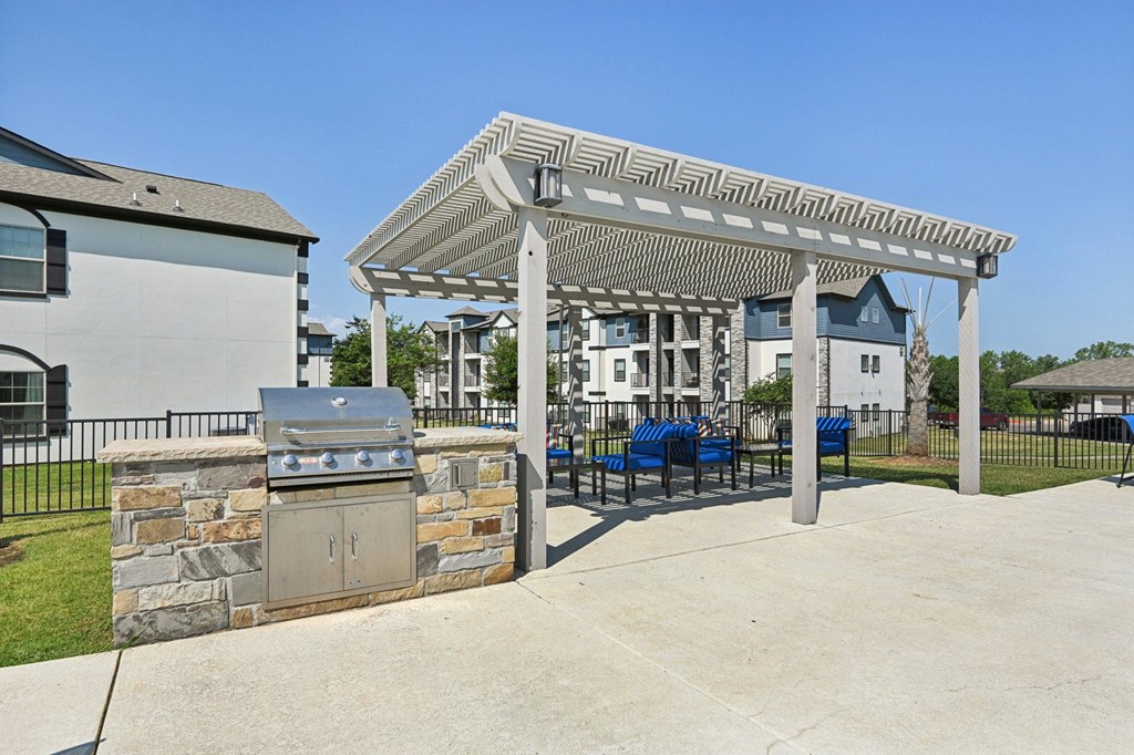 a patio with a barbecue grill and a pergola