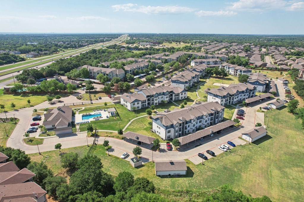 an aerial view of an apartment complex with houses and a parking lot