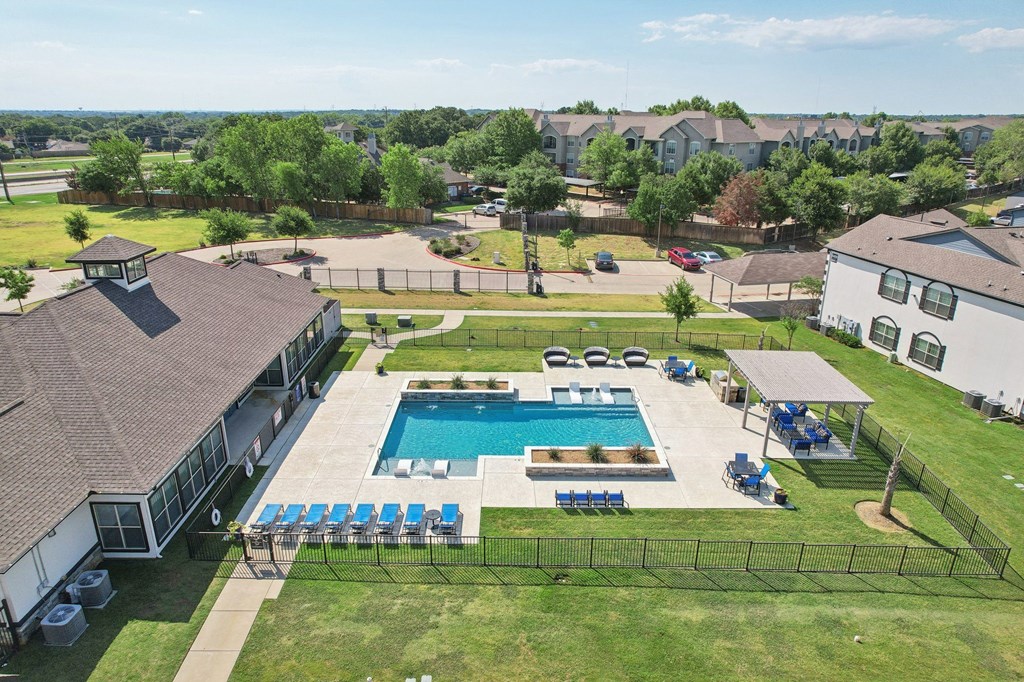 an aerial view of a swimming pool in front of a house