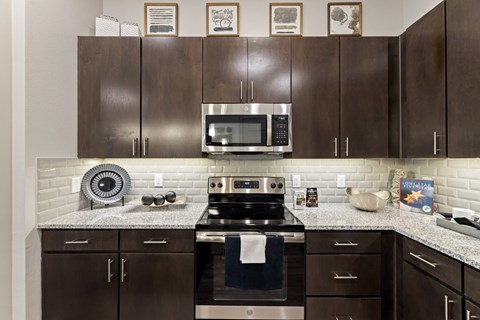 A kitchen with brown cabinets and a stove top oven.