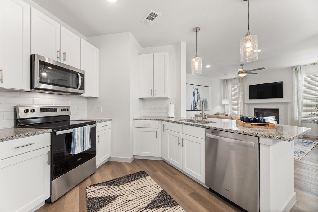 a renovated kitchen with white cabinets and stainless steel appliances