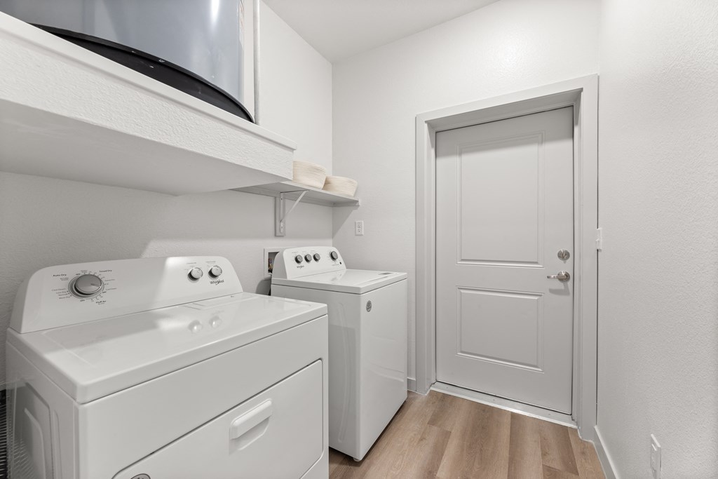 a white laundry room with a white washer and dryer and a white door