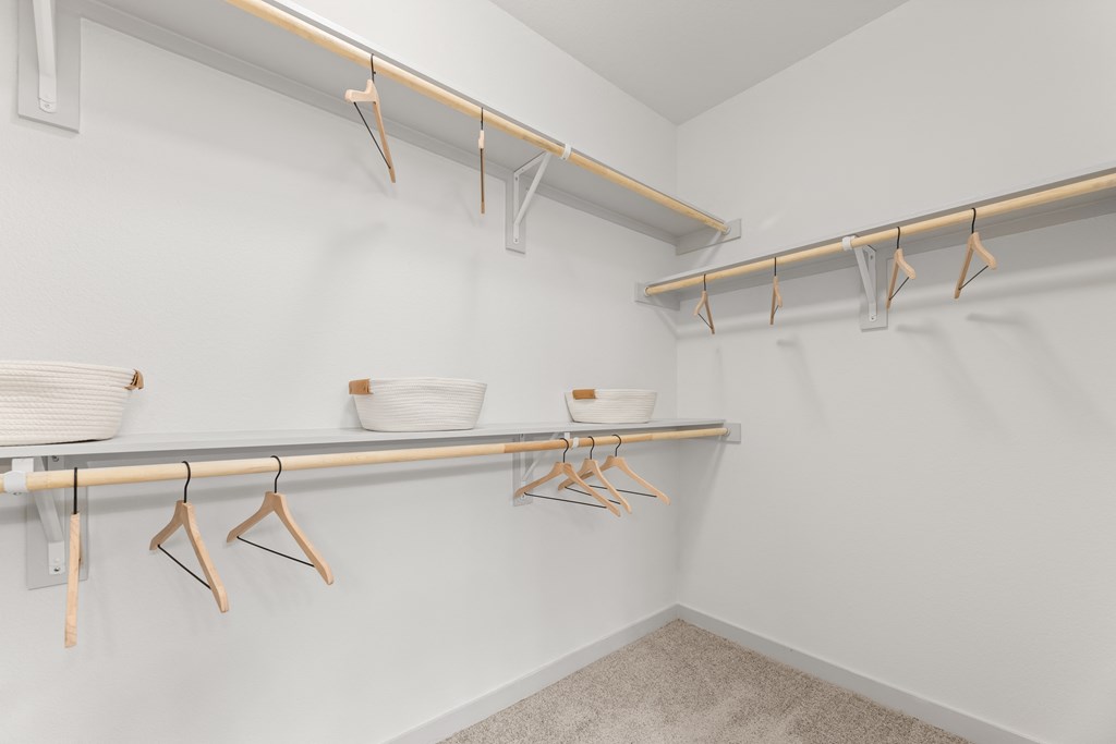 a spacious closet with shelves and hooks and a shelf with bowls on it