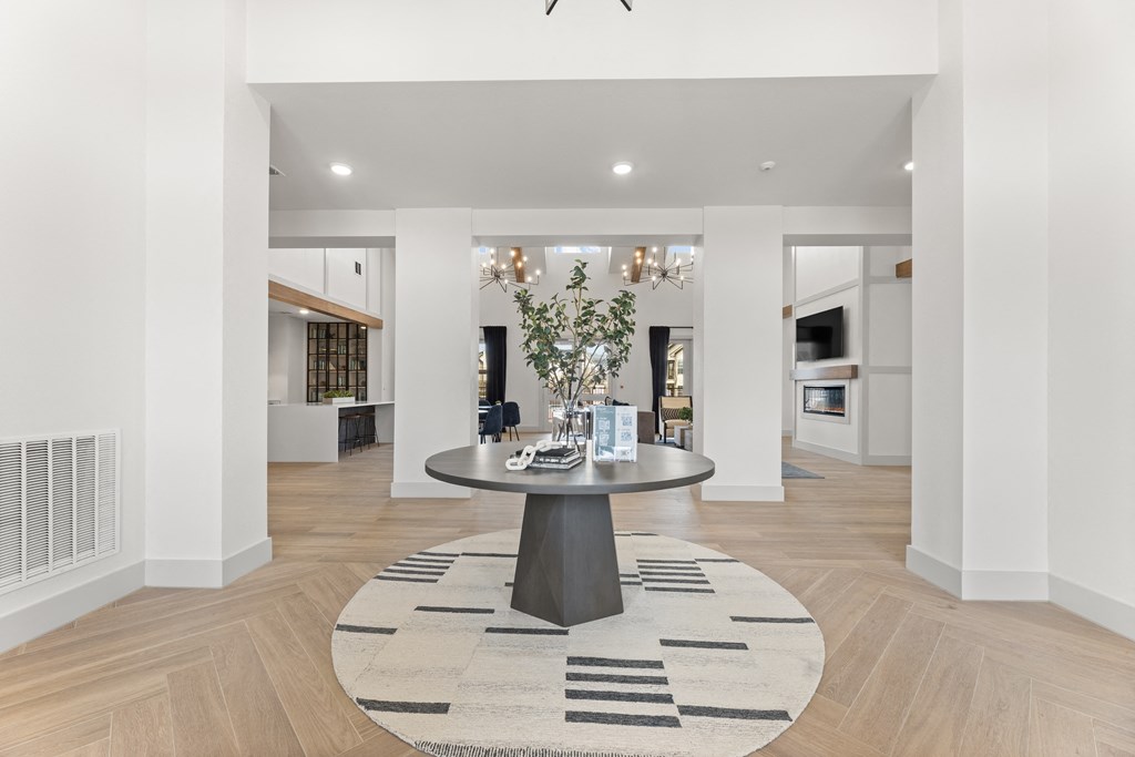a living room with a round table and a rug