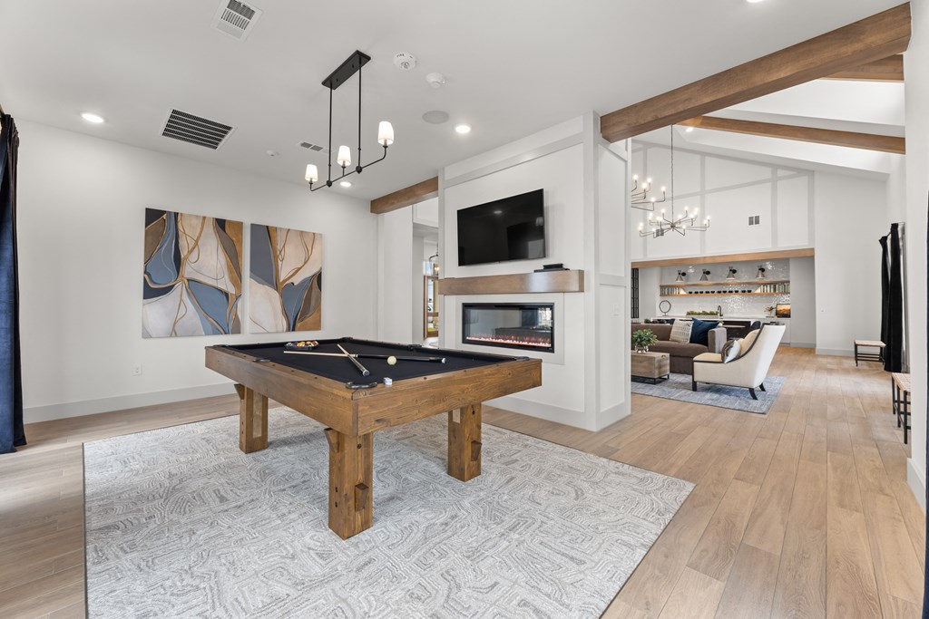 a living room with a pool table and a tv