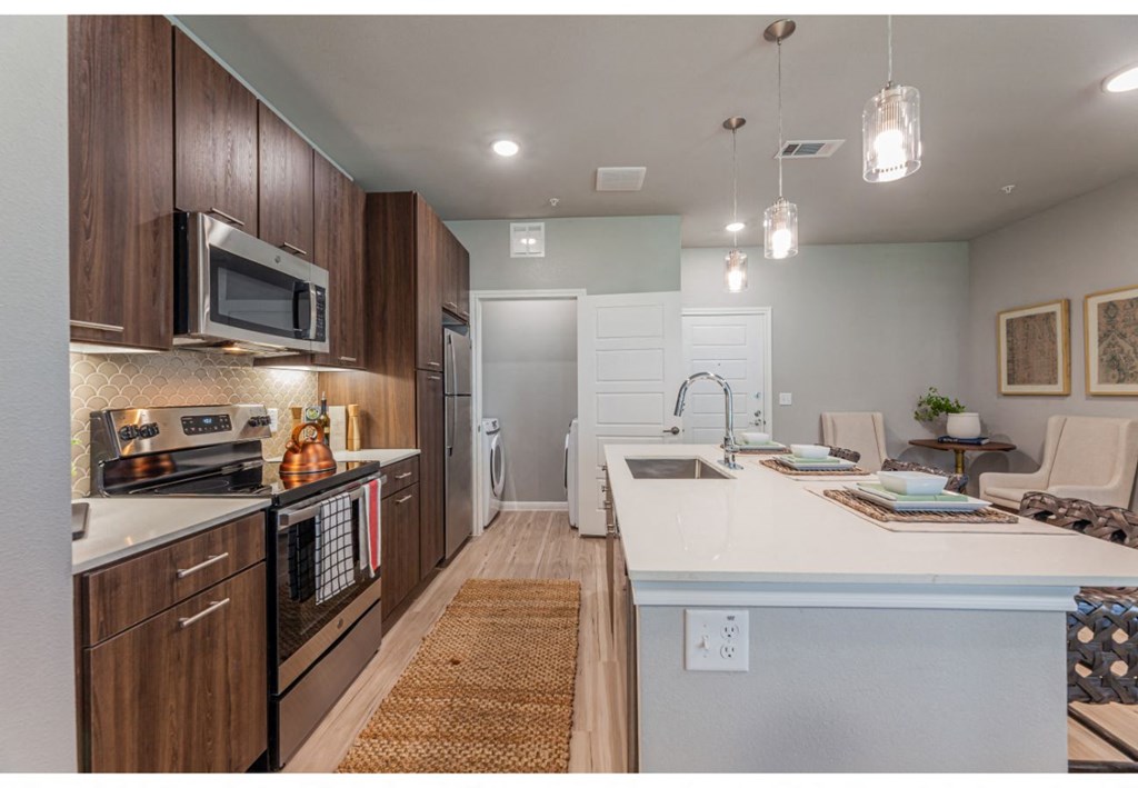 a large kitchen with a white counter top and a sink