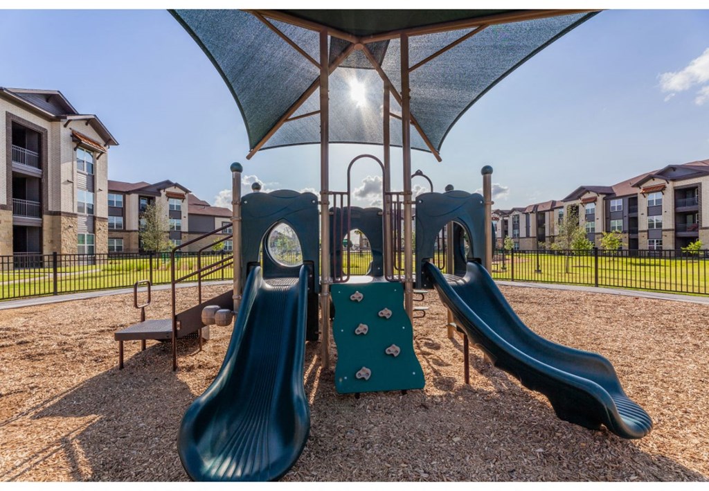 a playground with two slides and a swing set