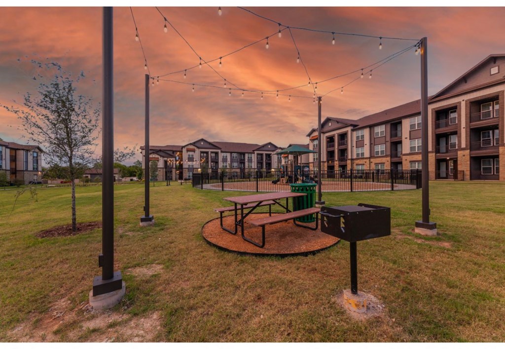 an image of a park with a playground and buildings