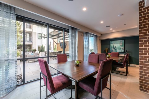 A seating area with a table and chairs facing a swimming pool.