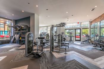 A gym with a variety of equipment including treadmills, weights, and exercise machines.