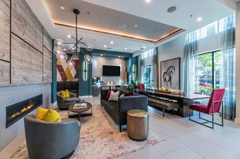 A modern living room with a fireplace and a grey sofa.