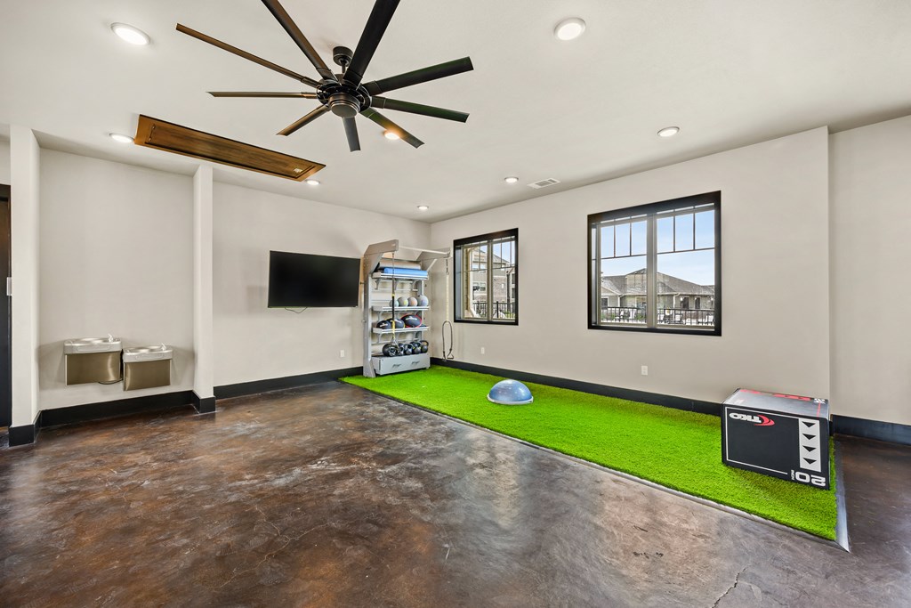 a room with a soccer ball on the floor and a tv on the wall