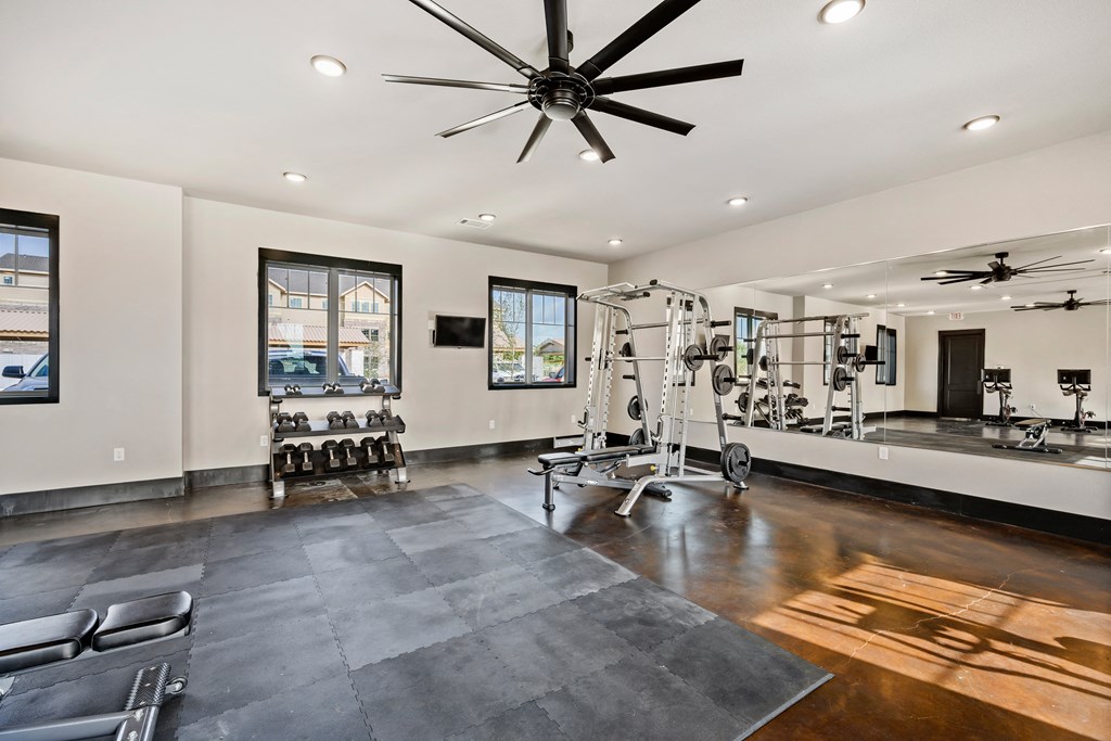 a home gym with a gym flooring and a ceiling fan