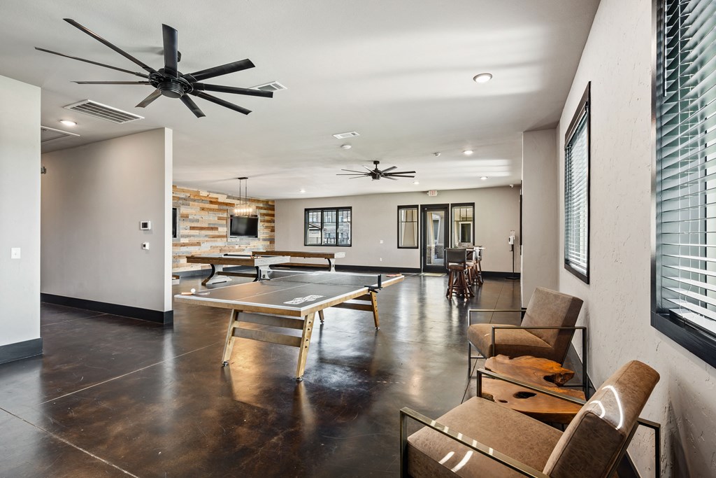 a game room with a ping pong table and couches