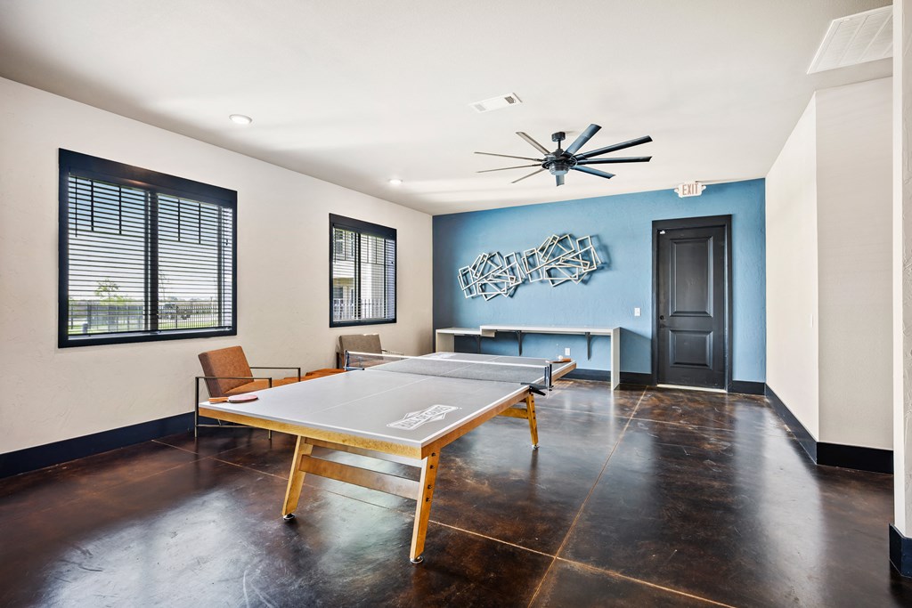 a game room with a ping pong table and chairs