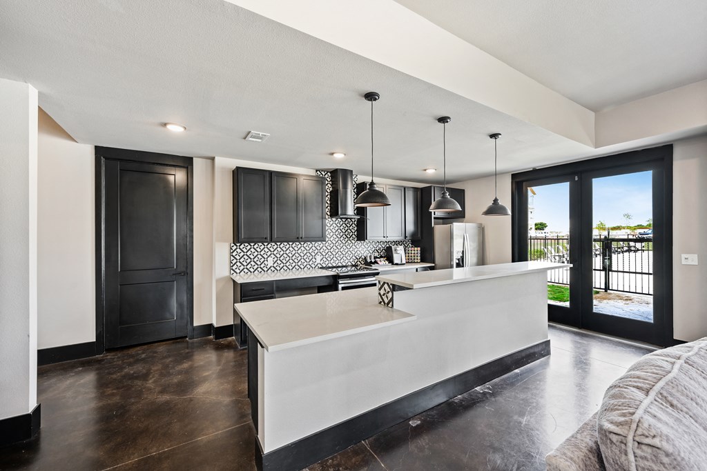 a kitchen with white countertops and black cabinets