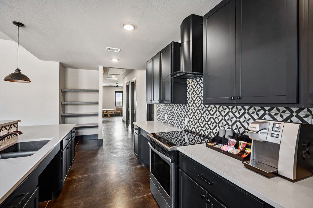 a kitchen with black cabinets and white countertops