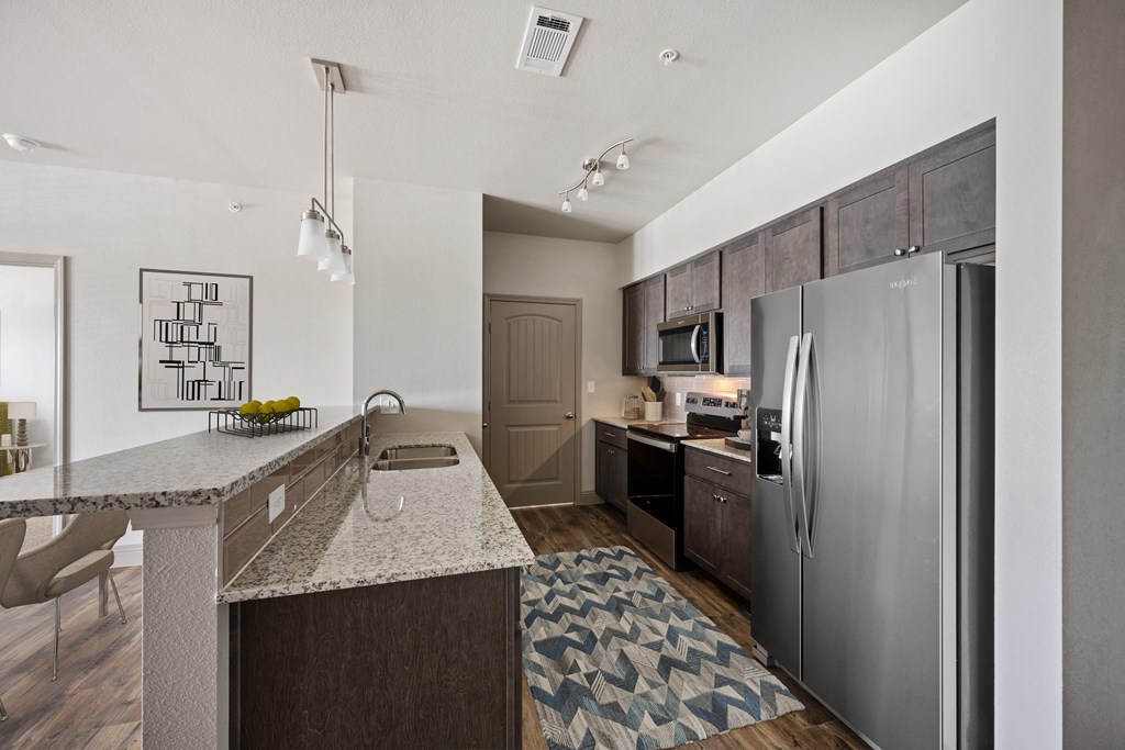 a kitchen with granite countertops and stainless steel appliances