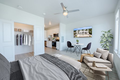 A modern bedroom with a large bed and a flat screen TV mounted on the wall.
