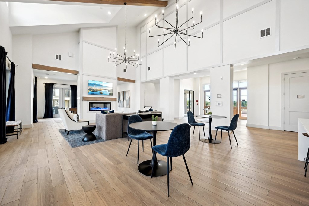 a communal area with a dining table and chairs and a living room