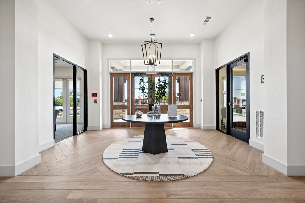 a foyer with a circular rug and a table in the middle