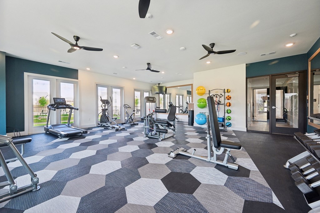 a gym with weights and cardio equipment on a checkered floor