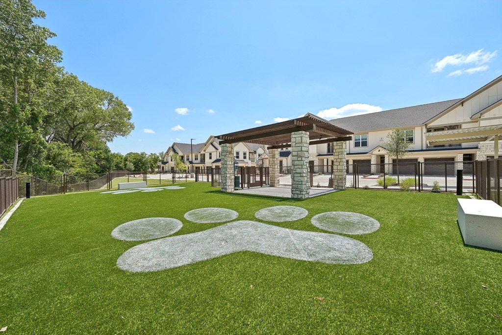 a yard with green grass and a building in the background