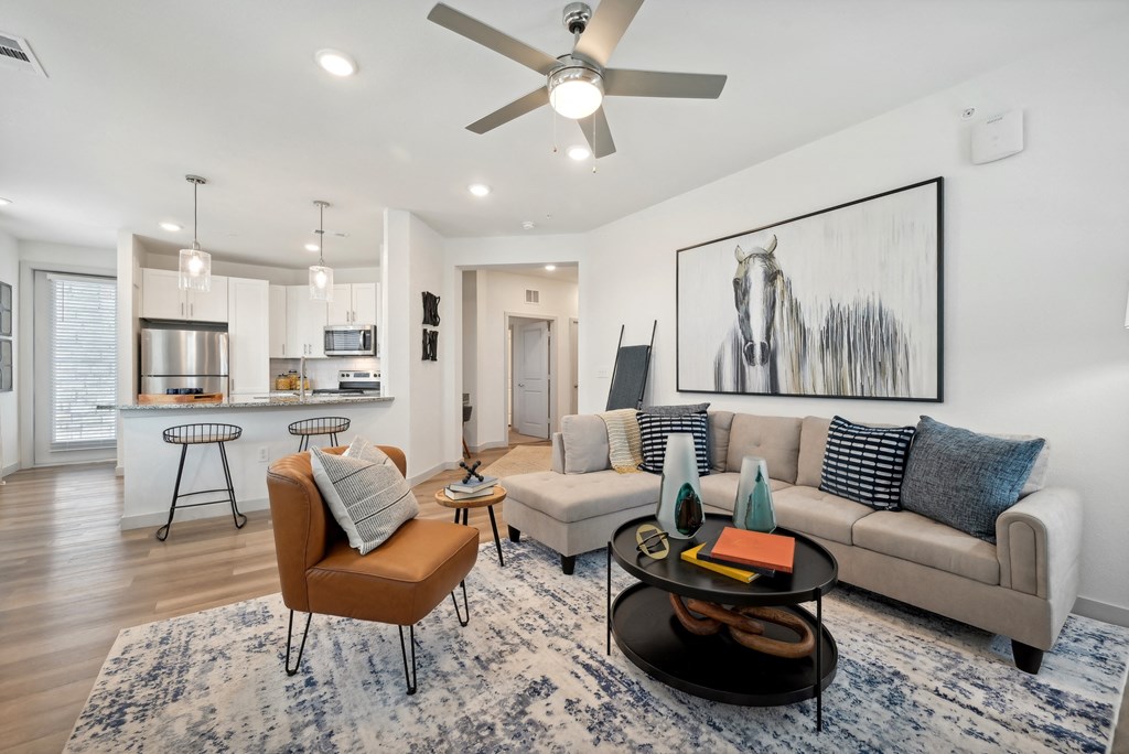 an open living room and kitchen with a ceiling fan